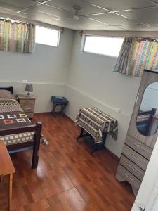 a bedroom with a bed and a table and two windows at Hab Simple baño compartido Estudiante o Voluntario terraza vista a los Volcanes in Arequipa