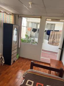 a room with a bedroom with a bed and a mirror at Hab Simple baño compartido Estudiante o Voluntario terraza vista a los Volcanes in Arequipa +1 photo