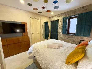 a bedroom with a bed and a flat screen tv at Botticelli 2 en ValQuirico in Santeagueda
