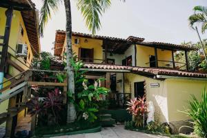 una casa con palmeras delante en Pousada Arraial Lua Crescente, en Arraial d'Ajuda
