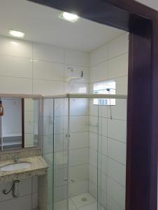 a bathroom with a glass shower and a sink at Hotel Sabrina in Guanamby