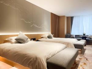 a hotel room with three beds and a couch at 上海天平宾馆 in Shanghai