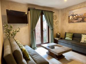 una sala de estar con un sofá y una mesa en Valeria en ValQuirico, en Santeagueda