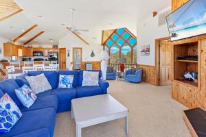 un salon avec un canapé bleu et une télévision dans l'établissement 1300 - Shore Pleasure, à Corolla