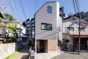 a white building with a door on a street at tai南元町25 in Tokyo