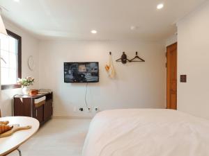 a bedroom with a bed and a tv on the wall at 포켓서울 여의도 in Seoul