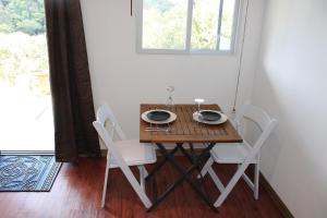 un tavolo in legno con sedie in una stanza con finestra di mountain cabin with private waterfall and river a Monteverde Costa Rica Altre 32 foto
