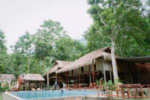 a resort with a swimming pool in front of a building at Puluong Ly Van Garden in Làng Chiêu
