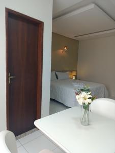 a bedroom with a bed and a vase of flowers on a table at Hotel Sabrina in Guanamby +8 photos