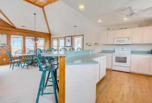 a kitchen with white cabinets and a table with chairs at 3035 - Morning View in Southern Shores