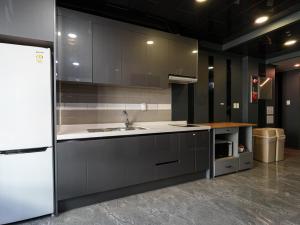 a kitchen with a sink and a white refrigerator at 포켓서울 여의도 in Seoul
