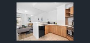 a kitchen with a sink and a stove top oven at East Perth Apartment Suites with Parking in Perth