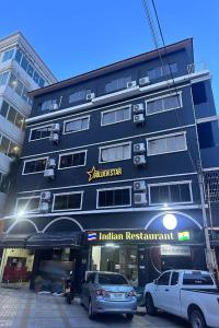 a black building with cars parked in front of it at Golden Star Pattaya in Ban Nong Chaeng