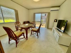 a living room with a table and chairs and a television at Hannan Village fifth in Hannan