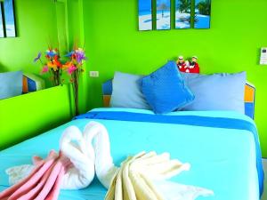 Un dormitorio con una cama azul con una pared verde. en Baan Navy Kohlarn, en Koh Larn