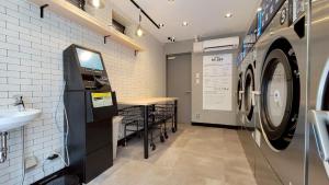 a laundry room with a sink and a washing machine at Port House Honmachi in Tokyo