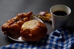 a plate of food with hot dogs and a cup of coffee at Uwajima Oriental Hotel in Uwajima
