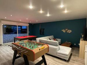 a living room with a foosball table and a couch at Villa Boubou 10 chambre in Troarn
