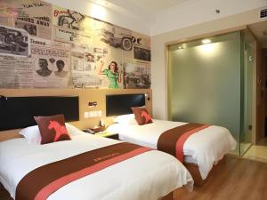 a hotel room with two beds and a wall with newspapers at Jun Hotel Zhejiang Ningbo Luzhou District Zhongxing Nan Road in Ningbo +63 photos