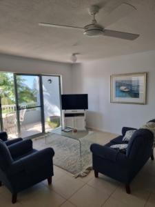 Una sala de estar con dos sofás y un televisor. en Blue Seas, en Coolum Beach