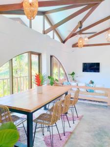 Un comedor con mesa y sillas de madera. en Villa Cali Siargao, en General Luna