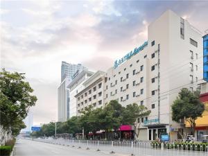 a large white building on a city street at Magnotel Hotel Suzhou Wanda Plaza Huaihai Road in Suzhou