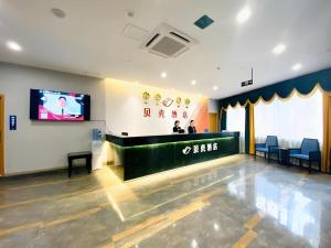 a waiting room with a bar with a tv on the wall at Shell Hotel Luzhou Longmatan District Dujia Street Riverside in Luzhou