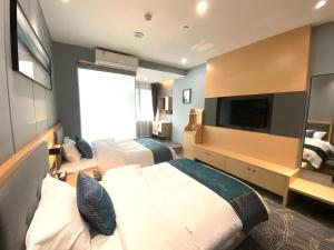 a hotel room with two beds and a flat screen tv at Shell Hotel Luzhou Longmatan District Dujia Street Riverside in Luzhou