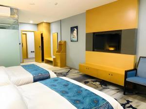 a hotel room with two beds and a flat screen tv at Shell Hotel Luzhou Longmatan District Dujia Street Riverside in Luzhou