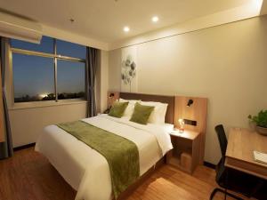 a bedroom with a large white bed and a window at GreenTree Inn Express Shandong Zaozhuang Shizhong District Huashan Road Ginza in Zaozhuang +210 photos