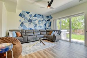 sala de estar con sofá gris y pared geométrica en FlightDeck HotTub Fireplace NearAirport FamilyHome, en Colorado Springs