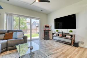 Una sala de estar con un sofá y un televisor de pantalla plana. en FlightDeck HotTub Fireplace NearAirport FamilyHome, en Colorado Springs