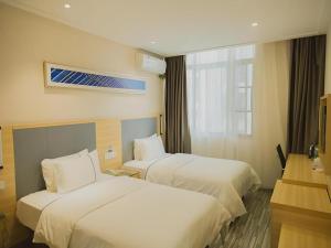 une chambre d'hôtel avec deux lits et une fenêtre dans l'établissement City Comfort Inn Nanchang Bayi Square Metro Station Wushang, à Nanchang 242 autres photos