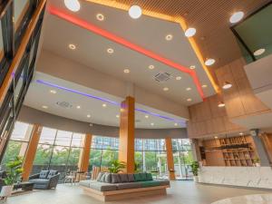 un hall d'entrée avec des canapés et des chaises dans un bâtiment dans l'établissement B2 Surat Thani Premier Hotel, à Surat Thani