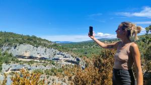 a woman taking a picture of a canyon with her cell phone at Fabetmie in Mormoiron +22 photos
