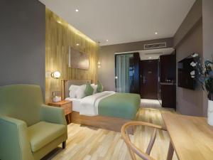 a bedroom with a bed and a chair and a table at VX Hotel Chengdu Wenjiang Guosetianxiang Chenyue in Chengdu +180 photos