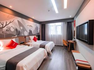 a hotel room with two beds and a flat screen tv at Thank Inn Guizhou Bijie Qianxi County High-Speed Railway Station in Qianxi
