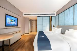 a bedroom with a large bed and a tv at Echarm Hotel Suzhou Shengze Oriental Extile City in Suzhou +213 photos