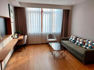 un salon avec un canapé et une table dans l'établissement Green Tree Inn Express Anhui Bozhou Mengcheng County Chengnan New District, à Zhuangzhou