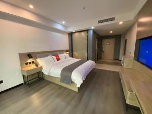 a bedroom with a large bed and a flat screen tv at Thank Inn Jiangxi Nanchang Anyi County Fenghuangshan Industrial Park in Nanchang