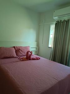 a bedroom with a pink bed with a teddy bear on it at Casa de ferias Tarciane Horizonte Ceara in Horizonte