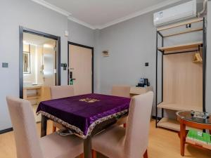 ein Esszimmer mit einem lila Tisch und Stühlen in der Unterkunft Green Tree Inn Hefei Railway Station International Auto Market Zhusitan Metro Station in Hefei