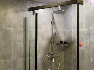 une douche avec une porte vitrée dans une salle de bain dans l'établissement Jun Hotel Jiangsu Nanjing Pukou District Linchang Metro Station, à Shenzhuang 83 autres photos