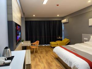 une chambre d'hôtel avec un lit et une télévision dans l'établissement Jun Hotel Jiangsu Nanjing Pukou District Linchang Metro Station, à Shenzhuang