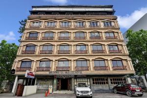 a tall building with cars parked in front of it at Townhouse OAK Hotel Belsons Taj Mahal in Hyderabad +41 photos