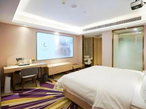 a hotel room with a bed and a projection screen at Lavande Hotel Wuhan Jianghan Road Jiqing Street in Wuhan