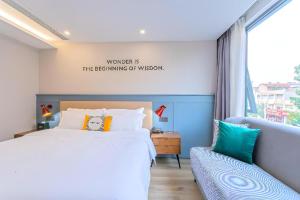 a bedroom with a bed and a window at Premier City Comfort Hotel Yangzhou Shouxi Lake West Gate Weiyang Road Siji Garden in Yangzhou