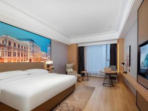 une chambre d'hôtel avec un grand lit et une télévision dans l'établissement Venus Royal Hotel Anhui Tongcheng Tongguoxiushui, à Wangguolu 89 autres photos