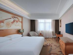 Ένα ή περισσότερα κρεβάτια σε δωμάτιο στο Vienna Hotel Hubei Jinzhou Jianli Jiangcheng