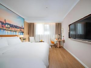 a hotel room with a large bed and a tv at Vienna Hotel Tianjin Chentangzhuang Metro Station in Tianjin